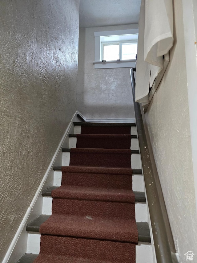 stairs featuring a textured wall