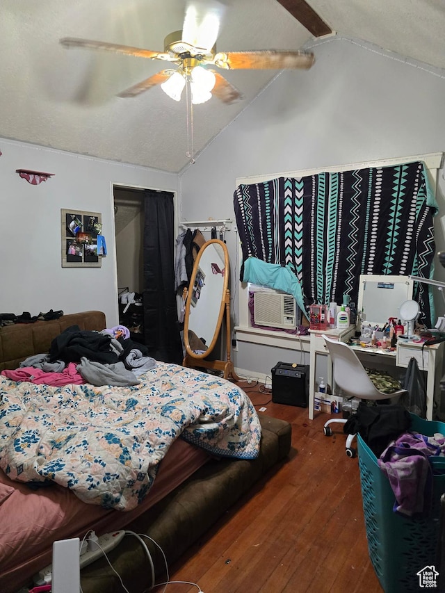 bedroom featuring vaulted ceiling, hardwood / wood-style flooring, cooling unit, a closet, and ceiling fan
