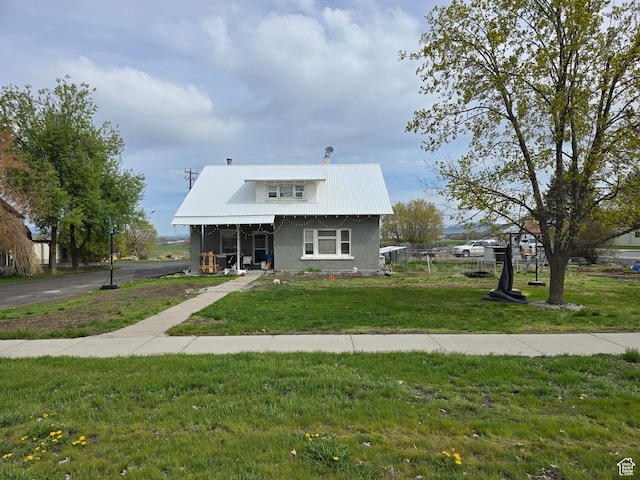 bungalow with a front yard and metal roof