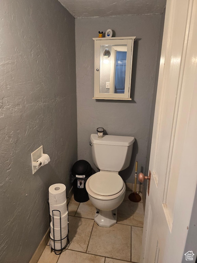 bathroom featuring toilet and tile patterned flooring