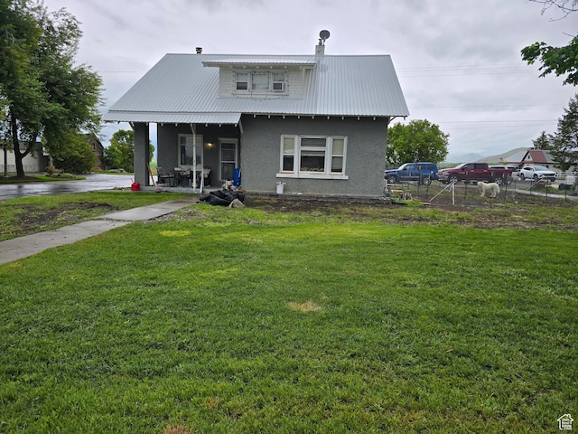 view of front of house with stucco siding, metal roof, and covered porch