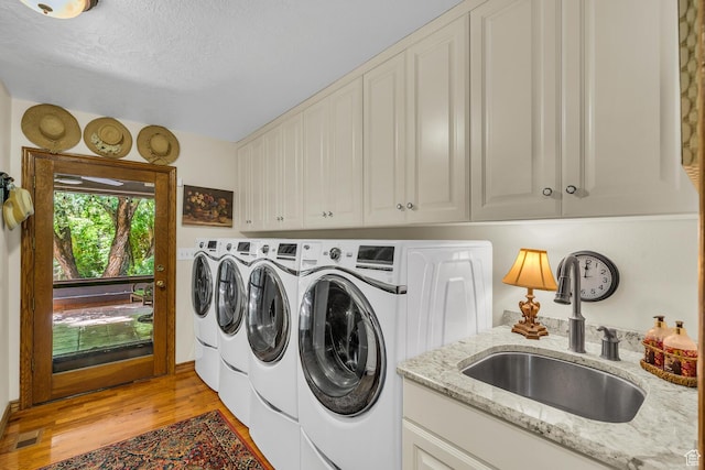 305 S Rachel Ln, New Harmony, UT 84757 - laundry room with washing machine and clothes dryer, cabinet space, light wood-style floors, and a textured ceiling