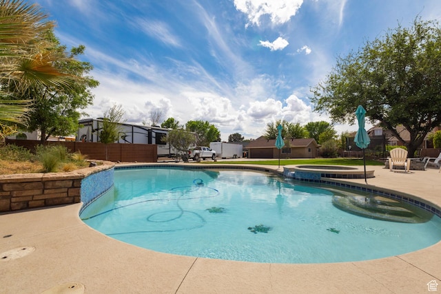 view of swimming pool with a patio area, fence, and a pool with connected hot tub