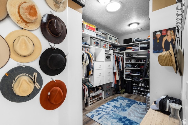 walk in closet with wood finished floors