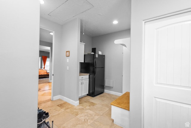 kitchen with freestanding refrigerator, white cabinetry, recessed lighting, baseboards, and light countertops
