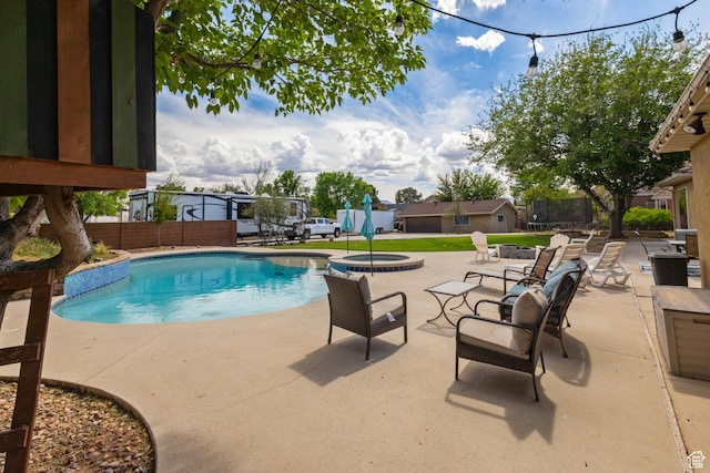 view of swimming pool with a patio area, a trampoline, fence, and a pool with connected hot tub