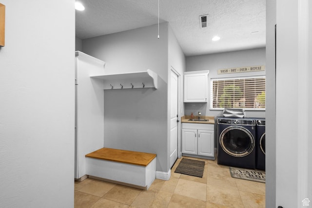 clothes washing area featuring cabinet space, washing machine and clothes dryer, recessed lighting, a textured ceiling, and baseboards