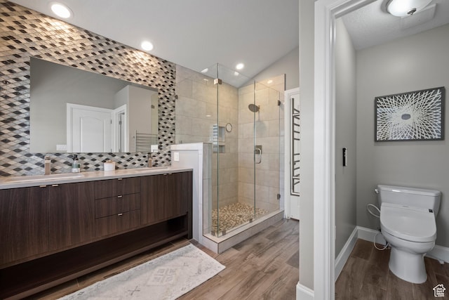 2242 E Deere View Dr N, Layton, UT 84040 - bathroom featuring wood finished floors, a stall shower, double vanity, toilet, and baseboards