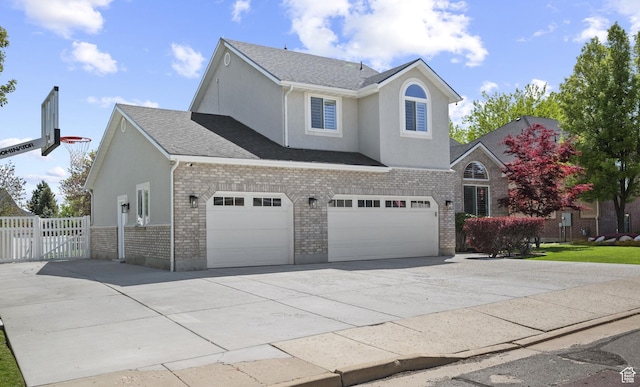 2242 E Deere View Dr N, Layton, UT 84040 - view of front of property featuring driveway, brick siding, fence, a garage, and stucco siding