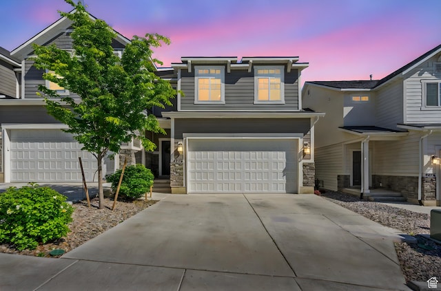 view of front of property featuring a garage, stone siding, and concrete driveway