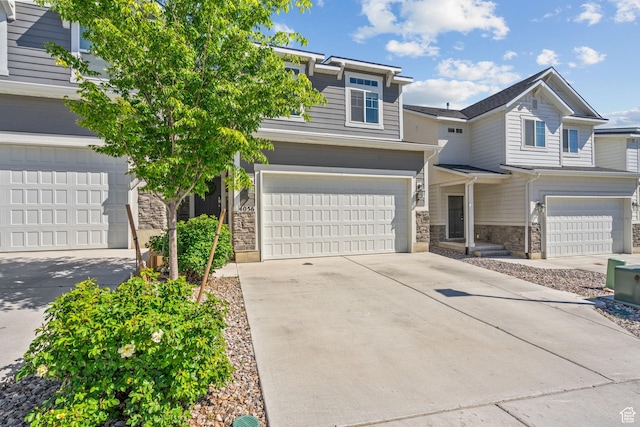view of front of home featuring stone siding, concrete driveway, and a garage