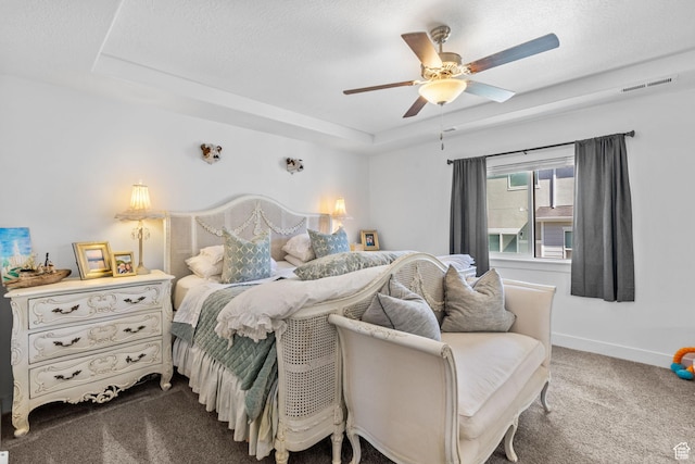 bedroom featuring carpet flooring, baseboards, a tray ceiling, and ceiling fan