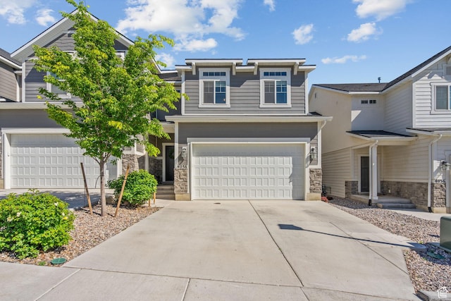 view of front facade with an attached garage, stone siding, and concrete driveway