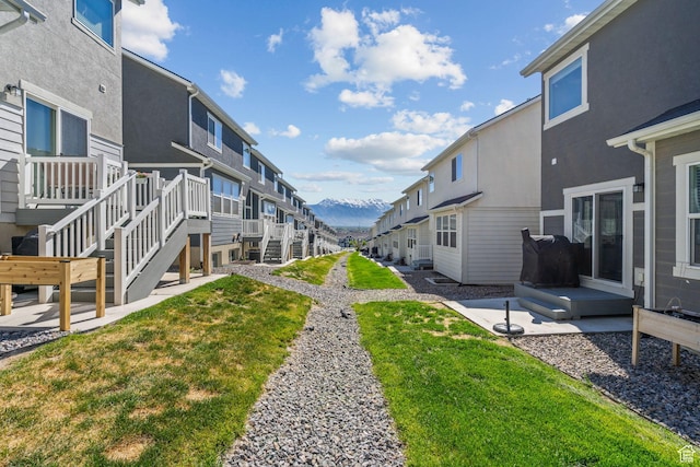 surrounding community with a lawn, a patio area, and a residential view