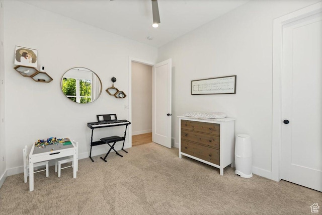 sitting room with carpet, ceiling fan, and baseboards