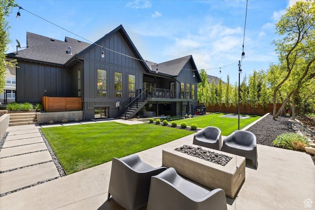 rear view of house featuring board and batten siding, stairway, a patio, and a wooden deck