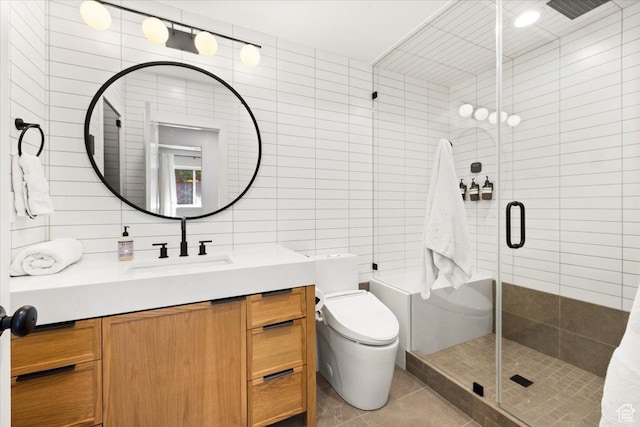 bathroom with a tile shower, tile walls, vanity, tile patterned flooring, and toilet