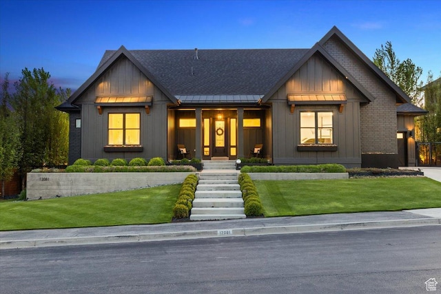 modern inspired farmhouse with a standing seam roof, board and batten siding, metal roof, and a yard