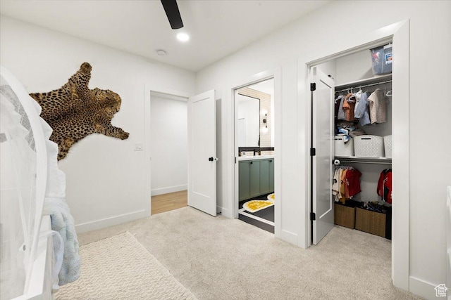 unfurnished bedroom featuring carpet, a closet, a walk in closet, ensuite bath, and baseboards