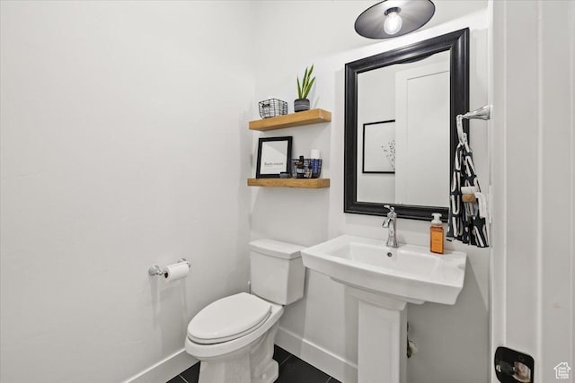 bathroom with baseboards and toilet