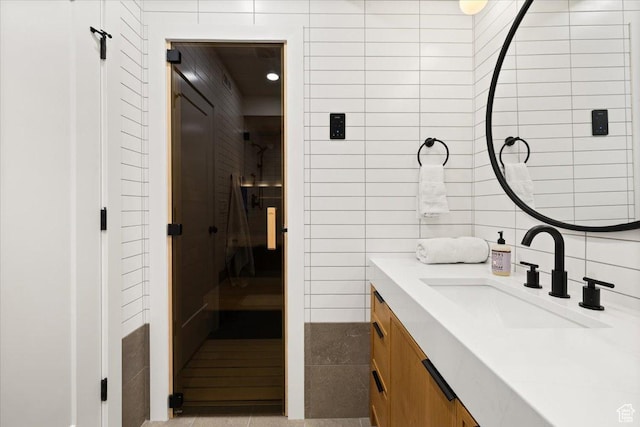 bathroom with tile walls, vanity, tile patterned flooring, tasteful backsplash, and a sauna / steam room