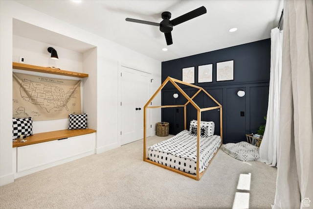 carpeted bedroom featuring recessed lighting, a decorative wall, and a ceiling fan