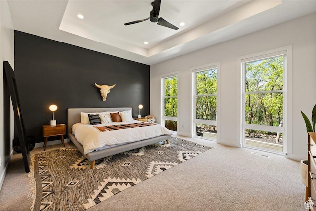 bedroom with recessed lighting, an accent wall, carpet flooring, a raised ceiling, and a ceiling fan