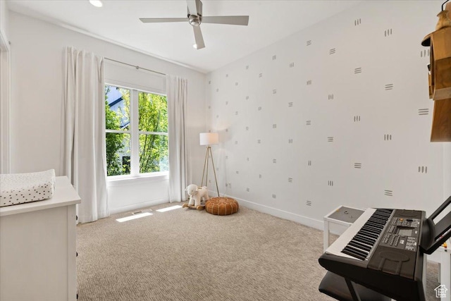 sitting room with carpet, a ceiling fan, and baseboards