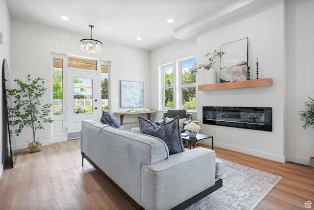 3670 S 1300 E, Millcreek, UT 84106 - living area featuring a glass covered fireplace, wood finished floors, baseboards, recessed lighting, and a chandelier