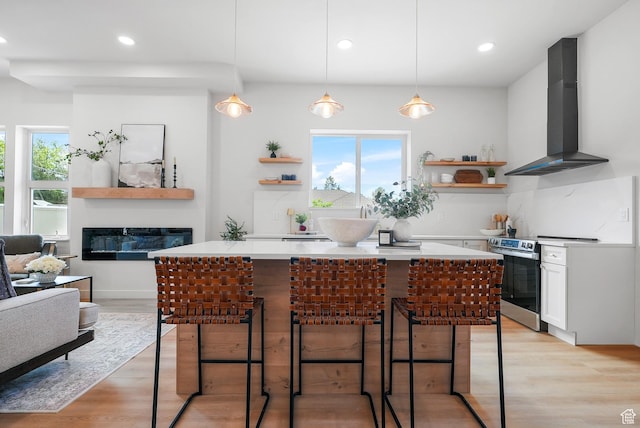 3670 S 1300 E, Millcreek, UT 84106 - kitchen with wall chimney range hood, stainless steel range with electric cooktop, open shelves, a glass covered fireplace, and recessed lighting