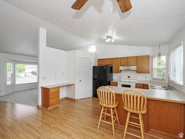kitchen featuring a sink, white range with electric cooktop, under cabinet range hood, black fridge with ice dispenser, and ceiling fan