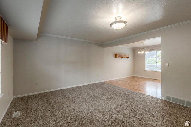unfurnished room with light colored carpet, a chandelier, crown molding, baseboards, and a textured ceiling