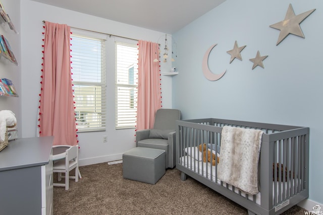 carpeted bedroom featuring a nursery area and baseboards