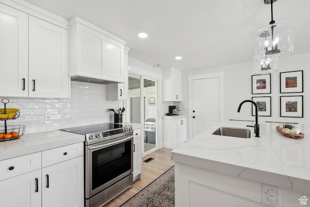 kitchen with stainless steel electric stove, a sink, white cabinets, light wood-style floors, and recessed lighting