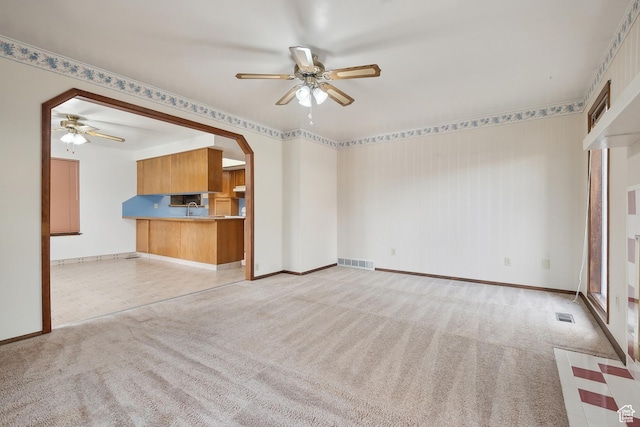 2268 W 5300 S, Roy, UT 84067 - unfurnished living room featuring a ceiling fan, carpet flooring, baseboards, and arched walkways