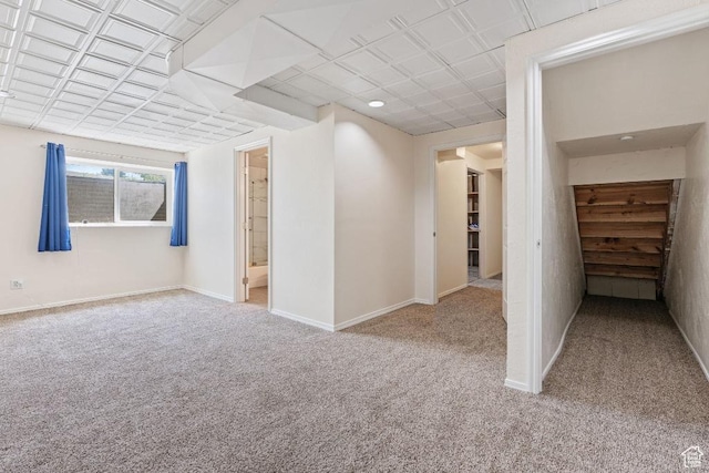 carpeted spare room featuring baseboards