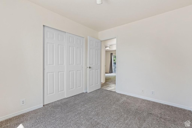 unfurnished bedroom with carpet, baseboards, and a closet
