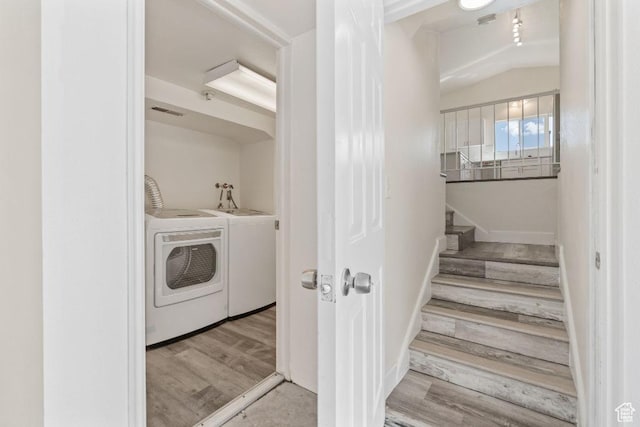 laundry area featuring washer and clothes dryer, wood finished floors, and baseboards
