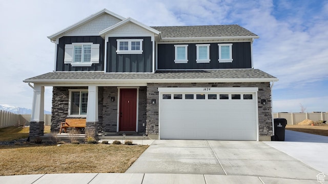 craftsman house with board and batten siding, driveway, a porch, and stone siding