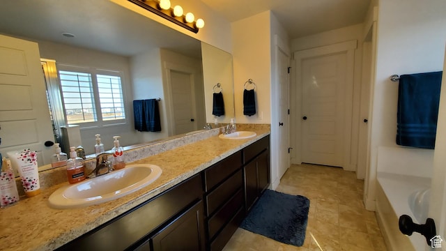 bathroom with double vanity, a bathtub, and tile patterned floors