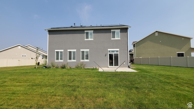 rear view of house with solar panels, a patio area, and stucco siding