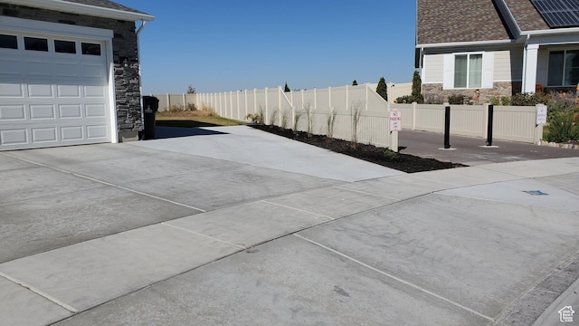 view of home's community featuring driveway, fence, and a garage