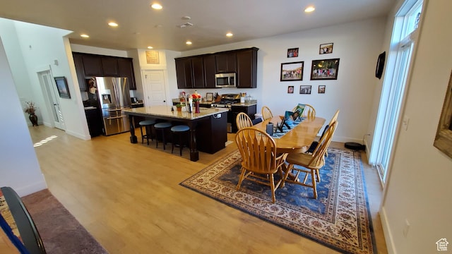 dining area with light wood-style flooring, recessed lighting, and baseboards