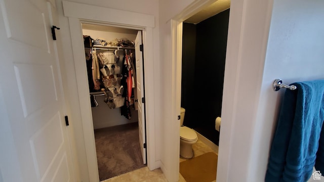 bathroom featuring toilet and a spacious closet