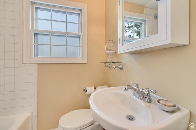 bathroom with a sink, toilet, and shower / washtub combination