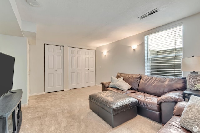 living area featuring light carpet and baseboards