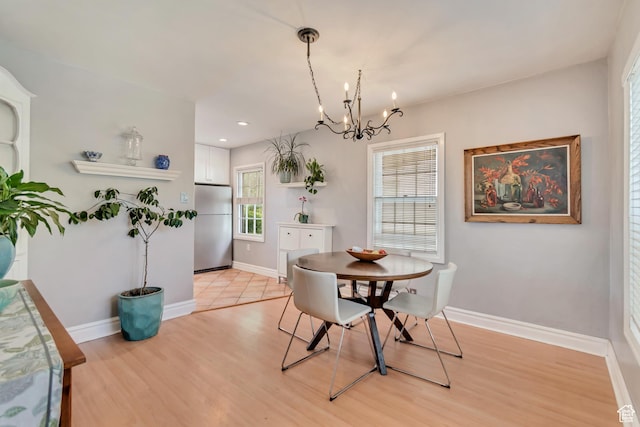 dining room with light wood finished floors, a chandelier, baseboards, and recessed lighting