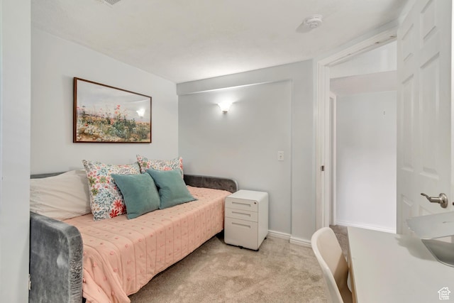 bedroom featuring light colored carpet and baseboards