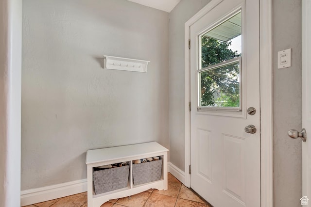 doorway to outside featuring plenty of natural light, baseboards, and light tile patterned flooring