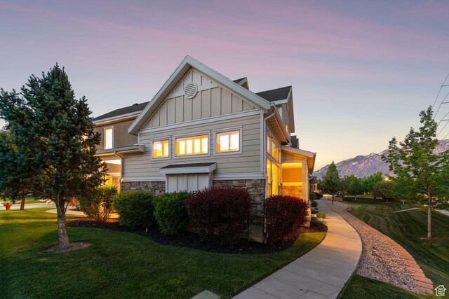 82 E Danta Dr S, Draper, UT 84020 - property exterior at dusk with board and batten siding, stone siding, a lawn, and a mountain view